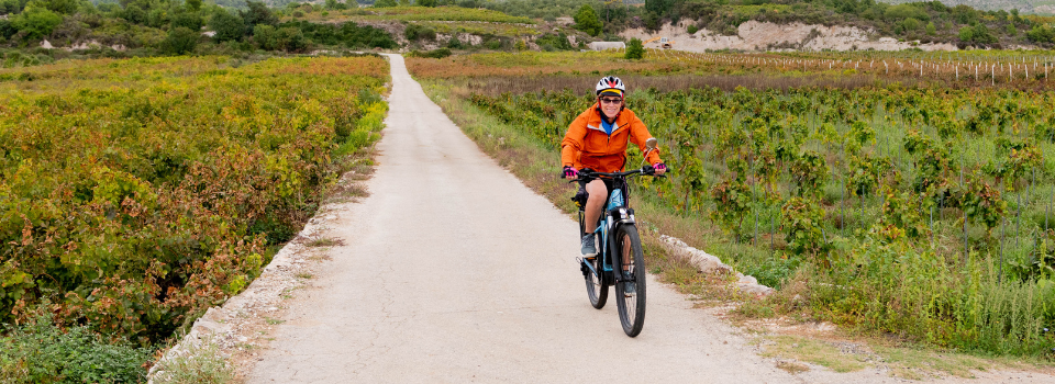 woman bikes a farm road in Dalmatia